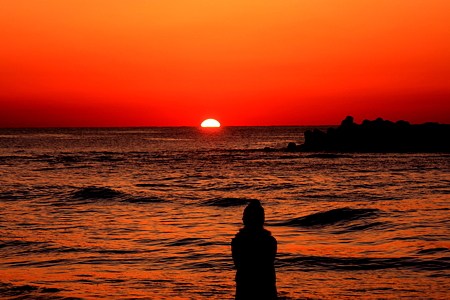 日本海に沈む夕陽を見る女の子(1)